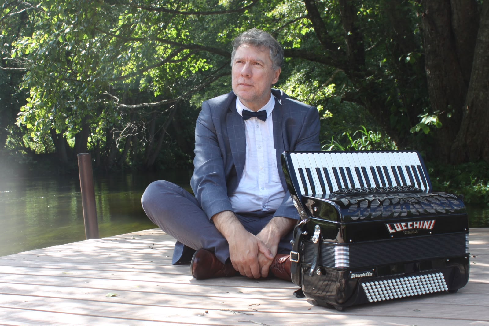 Krzysztof Szymanowski z akordeonem podczas sesji nad wodą